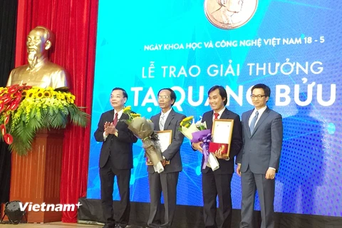 Phó Thủ tướng Vũ Đức Đam, Bộ trưởng Bộ KHCN Chu Ngọc Anh trao giải cho hai nhà khoa học xuất sắc. (Ảnh: T.H/Vietnam+