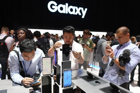 Khách hàng trải nghiệm điện thoại Galaxy Note 8 của Samsung. (Ảnh: AFP/TTXVN)
