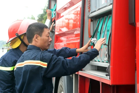 Thượng tá Đỗ Anh Quyến kiểm tra thiết bị trên xe cứu hỏa. (Ảnh: T.H/Vietnam+)