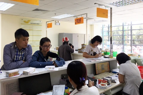 Người dân sử dụng dịch vụ tại Bưu điện Việt Nam. (Ảnh: CTV/Vietnam+)