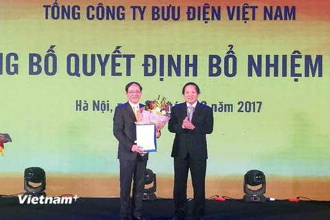 Bộ trưởng Bộ Thông tin và Truyền thông Trương Minh Tuấn (phải) trao Quyết định bổ nhiệm Chủ tịch VietnamPost. (Ảnh: PV/Vietnam+)