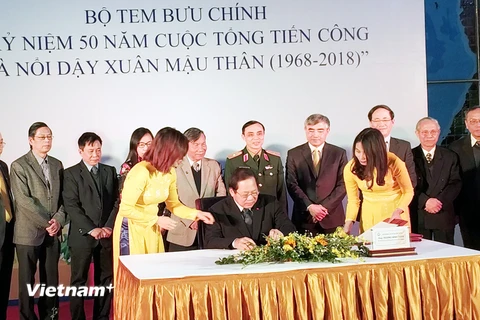 Bộ trưởng Bộ Thông tin và Truyền thông Trương Minh Tuấn ký phát hành bộ tem. (Ảnh: T.H/Vietnam+)