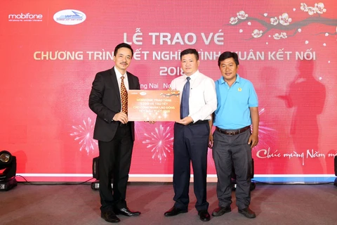 Ông Nguyễn Mạnh Hùng (trái) trao tặng tượng trưng vé tàu Tết giúp công nhân về quê. (Ảnh: MBF)