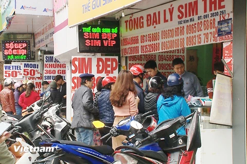 Nhiều người dân phải đợi đến lượt mới được mua thẻ cào vào sáng 28/2 tại phố Kim Mã. (Ảnh: PV/Vietnam+)