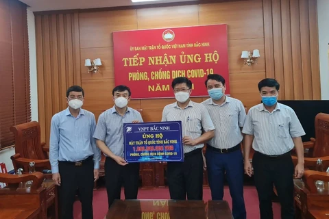 Đại diện VNPT trao tượng trưng quà ủng hộ cho Ủy ban Mặt trận Tổ Quốc tỉnh Bắc Ninh. (Ảnh: PV/Vietnam+)