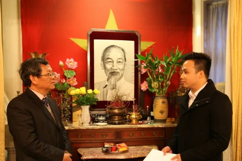 Ông Vũ Ngọc Hoàng (trái) tiếp nhận tiền từ thiện do sinh viên Việt Nam tại Anh quyên góp ủng hộ đồng bào miền Trung. (Ảnh: Lê Phương/Vietnam+)