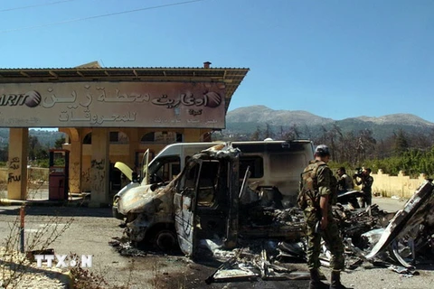 Xe ôtô bị đốt cháy trong cuộc giao tranh giữa quân đội chính phủ và lực lượng phiến quân ở Kasab. (Nguồn: AFP/TTXVN)