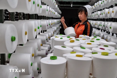 Công nhân làm việc tại nhà máy dệt ở tỉnh Hà Bắc, miền bắc Trung Quốc ngày 15/4. (Nguồn: THX/TTXVN)