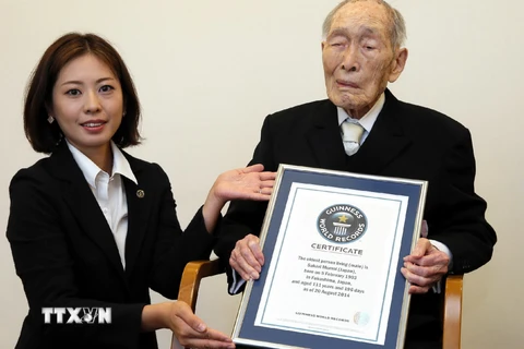 Cụ Sakari Momoi (phải) nhận giấy chứng nhận của Guinness tại Tokyo ngày 20/8/2014. (Nguồn: AFP/TTXVN)