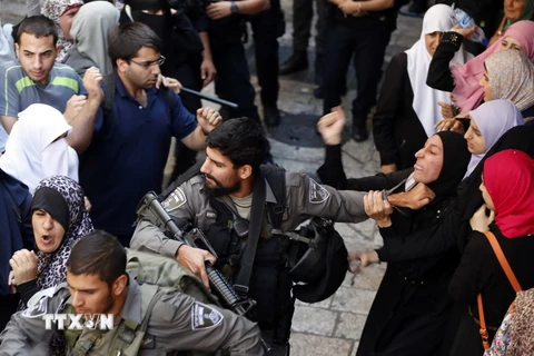 Cảnh sát Israel bắt giữ một phụ nữ Palestin trong cuộc xung đột giữa cảnh sát và người biểu tình. (Nguồn: AFP/TTXVN)