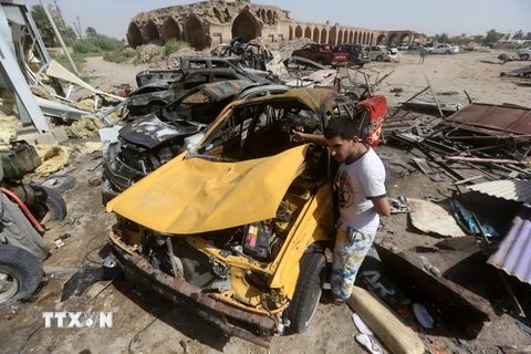 Xe ôtô bị phá hủy sau vụ đánh bom của IS tại thị trấn Khan Bani Saad. (Nguồn: AFP/TTXVN)