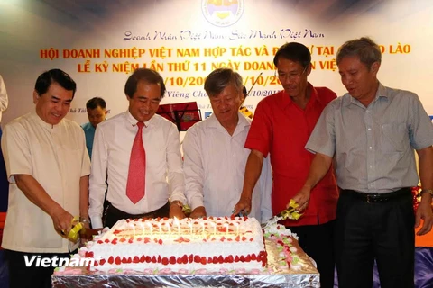 Đại sứ Nguyễn Mạnh Hùng (giữa) cùng các doanh nhân đang cắt bánh mừng sinh nhật lần thứ 11 của Doanh nhân Việt Nam. (Ảnh: Phạm Kiên/Vietnam+)