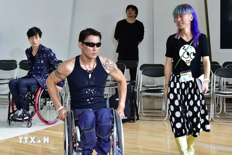 Yoshihiro Kojima ngồi trên xe lăn giới thiệu một trong các mẫu thời trang của nhà tạo mẫu Takafumi Tsuruta tại triển lãm ngày 13/10. (Nguồn: AFP/TTXVN)