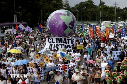 Hàng nghìn người đã tham gia vào các cuộc tuần hành chống biến đổi khí hậu trước thềm Hội nghị COP21. (Ảnh: AFP/TTXVN)