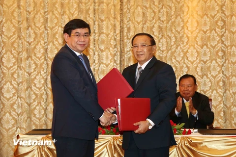 Ông Lienthikeo, Bộ trưởng Tài chính Lào và ông Phan Đức Tú, Tổng Giám đốc BIDV tại buổi ký kết. (Ảnh: Phạm Kiên/Vietnam+)