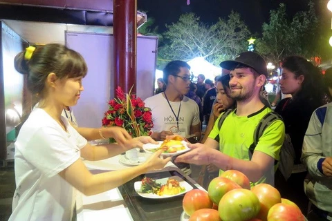Du khách nước ngoài thưởng thức món ăn Việt Nam. (Ảnh: Đỗ Trưởng/TTXVN)