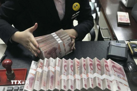 Nhân viên ngân hàng kiểm tiền nhân dân tệ tại Thượng Hải. (Nguồn: Reuters/TTXVN)