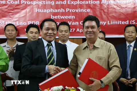 Ông Sisou Phanthong (phải), Thứ trưởng Bộ Kế hoạch Đầu tư Lào trao cho ông Phạm Ngọc Long (trái) Hợp đồng thăm dò và khai thác. (Ảnh: Phạm Kiên/TTXVN)