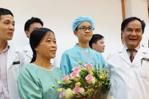 Giáo sư Bùi Đức Phú - Giám đốc Bệnh viện Đa khoa Quốc tế Vinmec Times City tặng hoa cho chị Huyền và con trai trong ngày xuất viện.