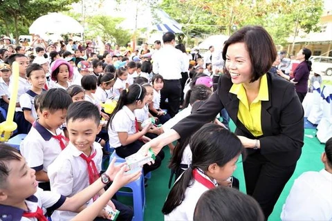 Bà Bùi Thị Hương - Giám đốc Điều hành Vinamilk trao sữa cho các em học sinh.