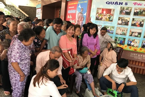 Người cao tuổi tới tham dự hội thảo hào hứng với hoạt động đo loãng xương. (Nguồn: Vietnam+)