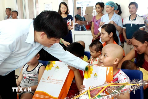 Thứ trưởng Bộ Y tế Nguyễn Thanh Long trao quà cho các bệnh nhi ung thư, tháng 9/2015. Ảnh minh họa. (Ảnh: Dương Ngọc/TTXVN)