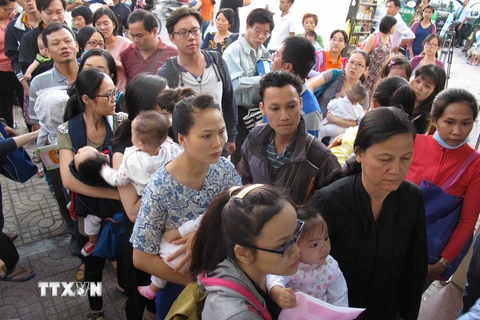 Người dân tại Thành phố Hồ Chí Minh xếp hàng tiêm vắcxin dịch vụ cho trẻ. (Ảnh: TTXVN)