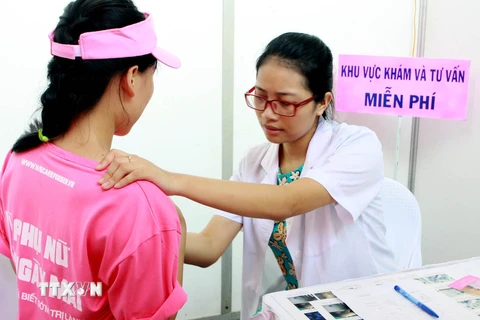 Nhân viên y tế khám sàng lọc ung thư vú cho người dân. (Ảnh: TTXVN)