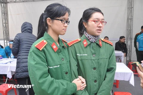 Hoàng Nhã Phương (bên phải) - cô sinh viên năm thứ 4 của Học viện Quân Y, rất vui vẻ và hồ hởi đến viết vào bản đăng ký hiến tạng. (Ảnh: PV/Vietnam+)