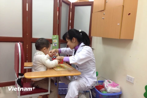 Nhân viên y tế của Bệnh viện Nhi Trung ương can thiệp, dạy cho trẻ có hội chứng tự kỷ. (Ảnh; PV/Vietnam+)