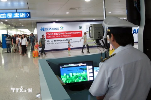 Theo dõi thân nhiệt hành khách tại sân bây Quốc tế Tân Sơn Nhất, Thành phố Hồ Chí Minh. (Ảnh: Phương Vy/TTXVN).