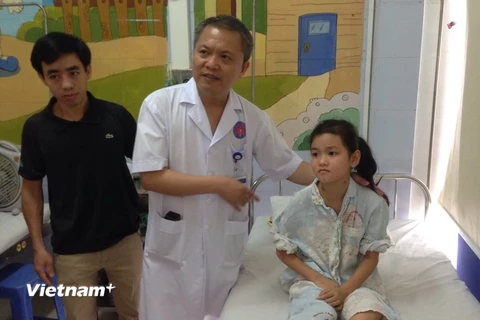 Giáo sư Lê Ngọc Thành thăm hỏi, kiểm tra sức khỏe bệnh nhân Tân sau mổ. (Ảnh: T.G/Vietnam+)