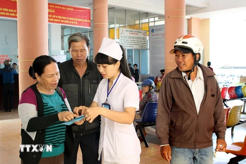Nhân viên y tế hướng dẫn người dân khám chữa bệnh. (Ảnh: TTXVN/Vietnam+)