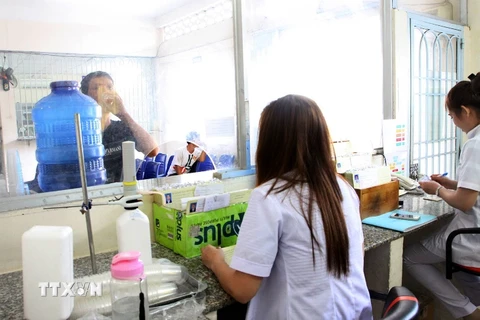 Nhân viên y tế giám sát điều trị Methadone cho bệnh nhân nhiễm HIV/AIDS. (Ảnh: TTXVN/Vietnam+)