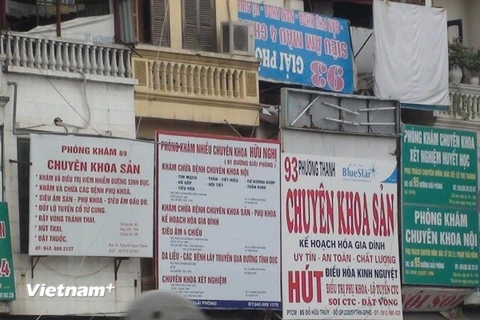Biển quảng cáo của các cơ sở y tế tư nhân san sát nhau tại Hà Nội. (Ảnh: PV/Vietnam+)