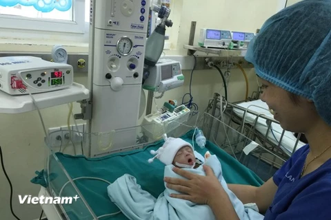 Nhân viên y tế chăm sóc bệnh nhi sau phẫu thuật tim. (Ảnh: PV/Vietnam+)