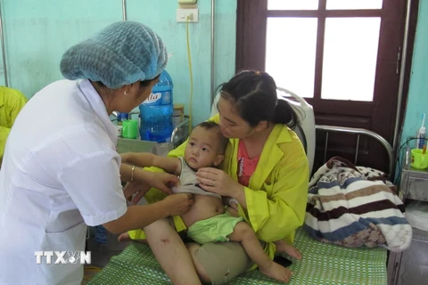 Nhân viên y tế chăm sóc cho bệnh nhi. (Ảnh: TTXVN/Vietnam+)