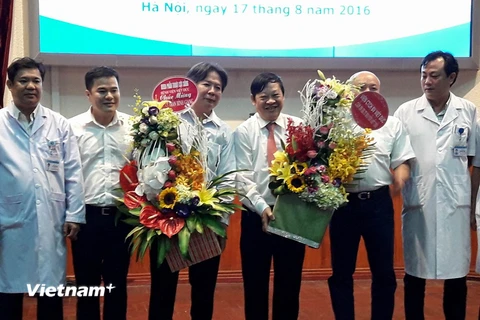 Giáo sư Trần Bình Giang (thứ ba từ trái sang) và Thứ trưởng Nguyễn Viết Tiến (thứ tư từ trái sang) tại buổi lễ bàn giao. (Ảnh: Thùy Giang/Vietnam+)