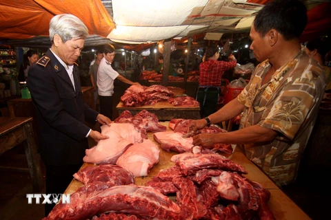 Nhân viên Thú y kiểm tra sản phẩm thịt lợn tại một hộ kinh doanh ở Phú Yên. (Ảnh: Vũ Sinh/TTXVN)