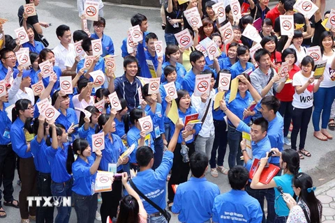 Sinh viên tình nguyện ra quân dán biểu tuợng cấm hút thuốc lá trên địa bàn thủ đô. (Ảnh: TTXVN/Vietnam+)