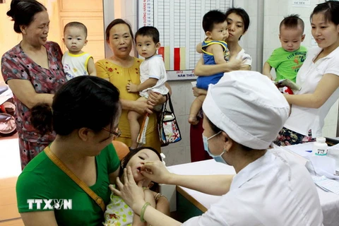 Nhân viên y tế cho trẻ uống Vitamin A. (Ảnh: TTXVN/Vietnam+)