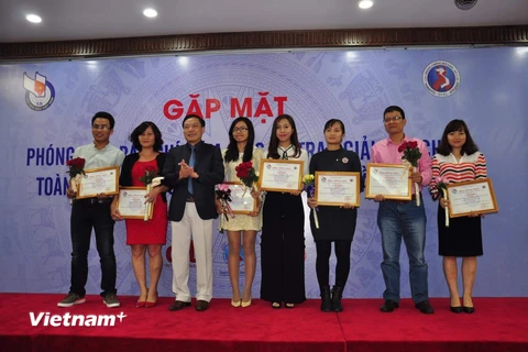 Ban tổ chức trao giải cho các tác giả đoạt giải. (Ảnh: PV/Vietnam+)