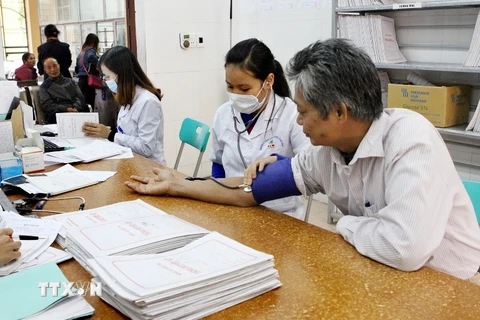 Nhân viên y tế khám,theo dõi sức khỏe cho người dân. (Ảnh: TTXVN/Vietnam+)