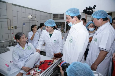 Bộ trưởng Bộ Y tế thăm bệnh nhân đang điều trị tại Bệnh viện Bạch Mai. (Ảnh: PV/Vietnam+)