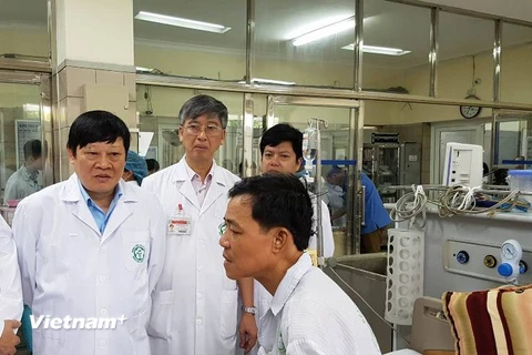 Thứ trưởng Bộ Y tế tới thăm bệnh nhân vừa được chuyển về điều trị tại Bệnh viện Bạch Mai. (Ảnh: PV/Vietnam+)