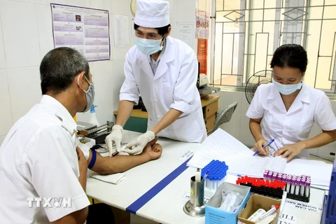 Nhân viên y tế lấy máu xét nghiệm cho bệnh nhân. (Ảnh: Dương Ngọc/TTXVN)