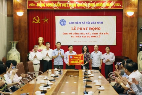 Hình ảnh tại buổi lễ quyên góp ủng hộ đồng bào lũ lụt. (Ảnh: PV/Vietnam+)