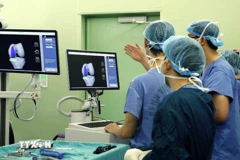 Cán bộ y tế hội chẩn kết quả chụp CT khớp gối của bệnh nhân tại Bệnh viện Bach Mai. (Ảnh: Dương Ngọc/TTXVN)