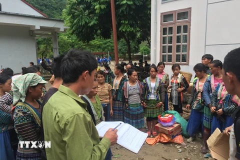 Phát hàng hỗ trợ cho người dân bị ảnh hưởng bởi lũ tại xã Nặm Păm, Sơn La. (Ảnh: Hữu Quyết/TTXVN)