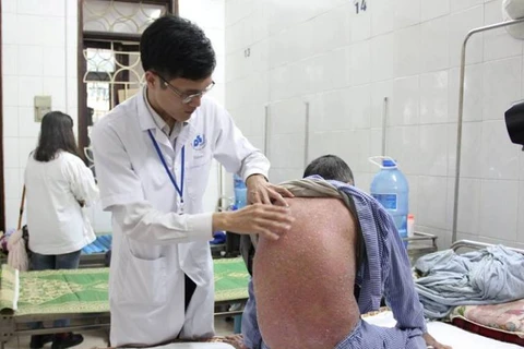Bác sỹ khám cho một bệnh nhân bị bệnh vảy nến. (Ảnh: PV/Vietnam+)